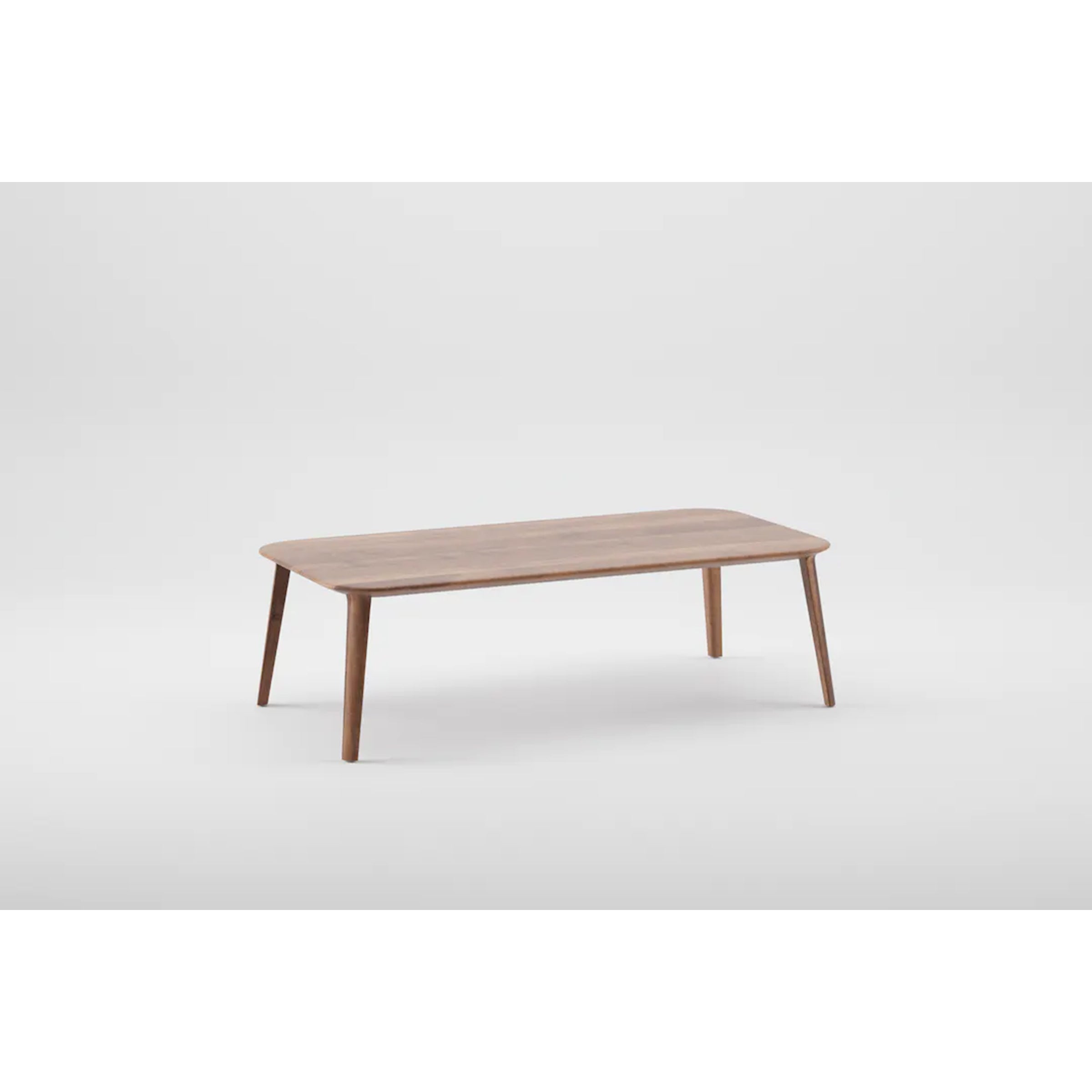 The KALOTA Coffee Table by Artisan is a minimalist design crafted from solid wood, featuring a rectangular top with rounded edges, supported by four slightly angled legs. Its treated with natural oils and showcased against a plain white background.