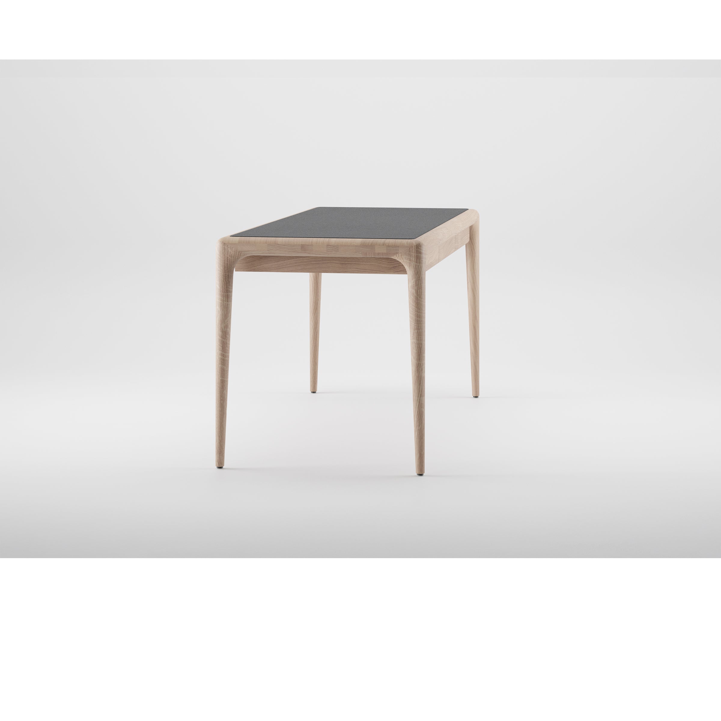 The LATUS Leather Desk by Artisan is a minimalist desk with a dark rectangular leather tabletop and tapered wooden legs. Set against a plain white background, it highlights the use of eco-friendly materials.