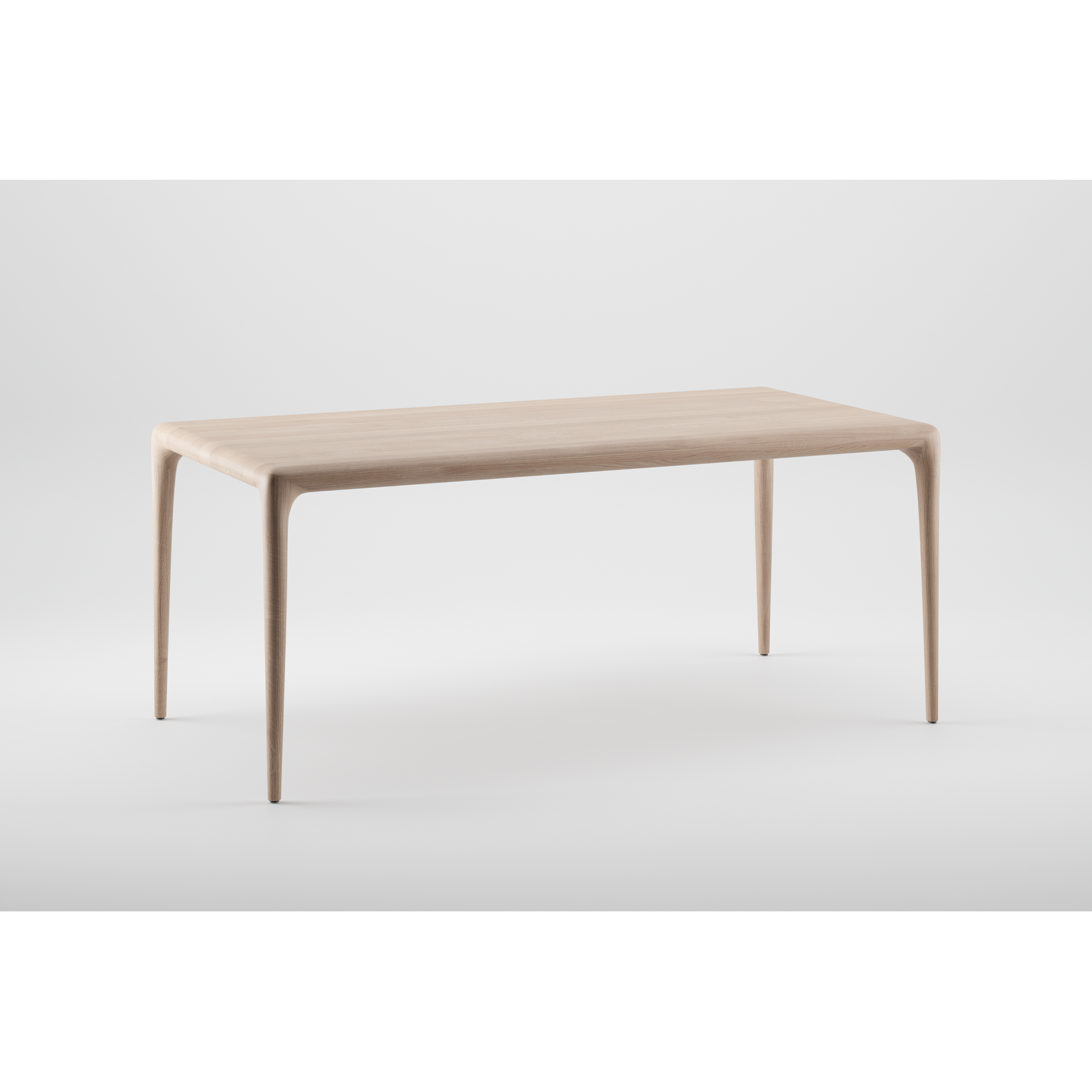 The LATUS Table by Artisan is a minimalist design crafted from solid wood, featuring smooth, gently curved edges and four slender legs. Its finished with natural oils and displayed against a plain white background.