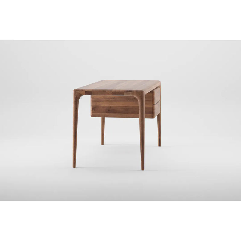 The Artisan LATUS Desk boasts a sleek, modern look with its solid wood construction and slim, tapered legs. Its minimalist design and smooth finish highlight its organic beauty, creating a contemporary feel against a light gray backdrop.