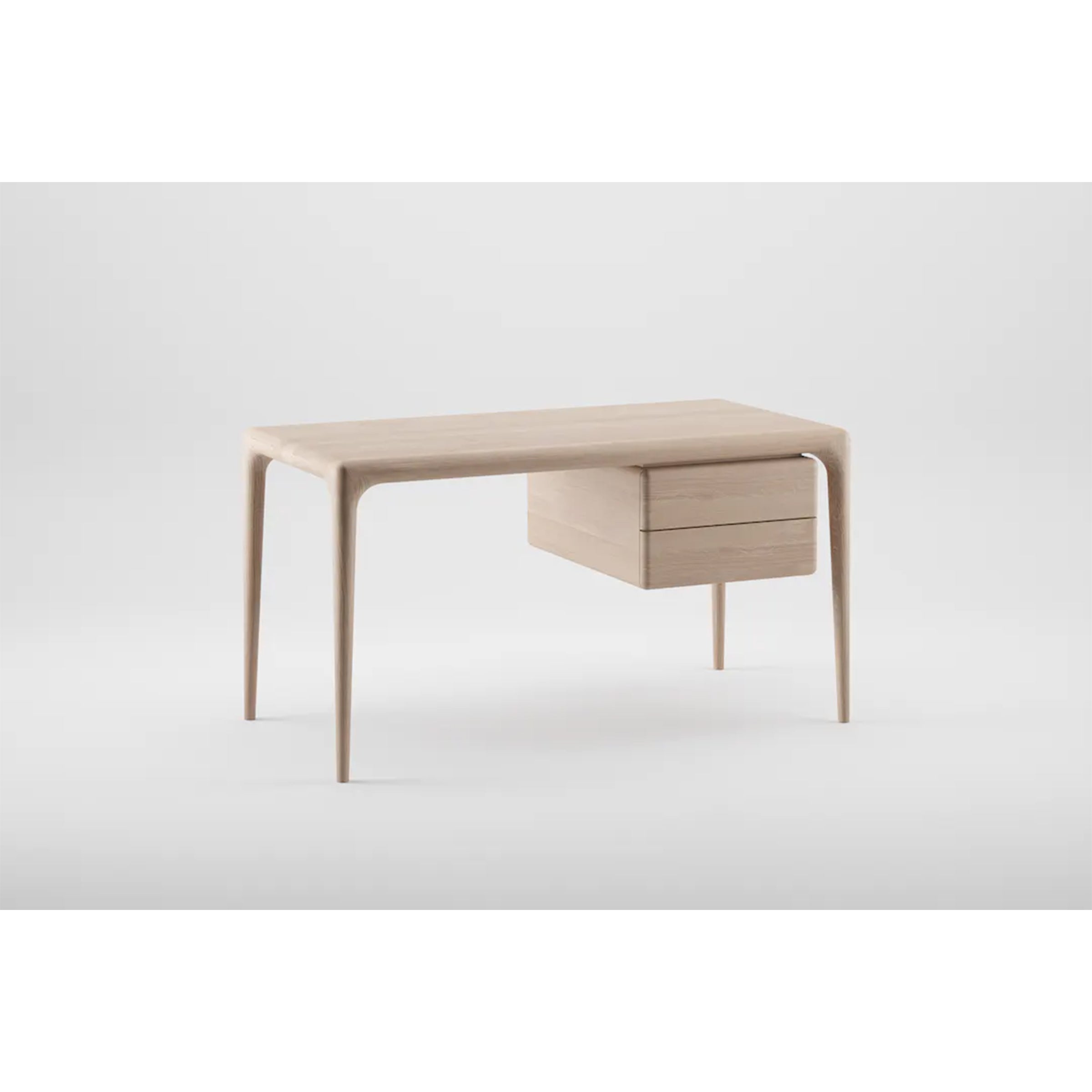 The LATUS Desk by Artisan is a minimalist piece featuring sleek, tapered legs and two right-side drawers. Crafted from solid wood, it boasts a light, natural finish set against a plain white background, highlighting its organic beauty.