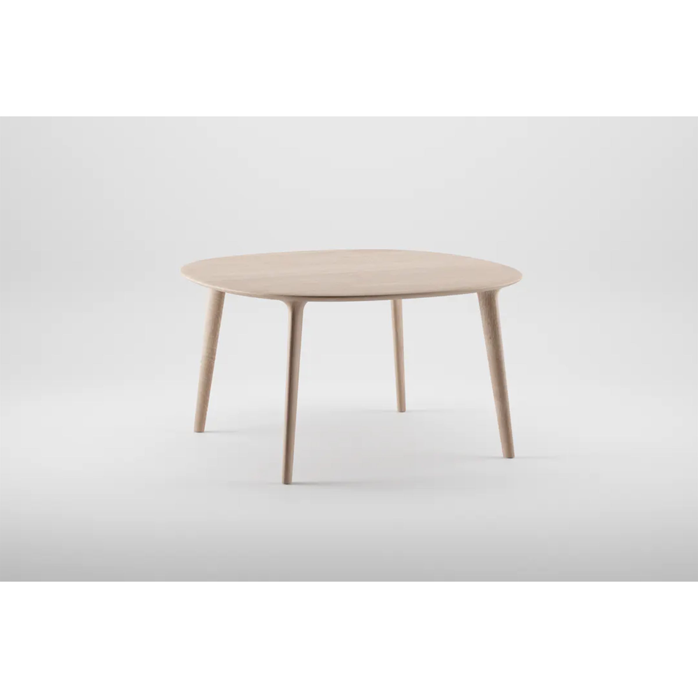 The LUC Table Round - Sale by Artisan features a minimalist design with four sleek legs and exquisite wood finishes, set against a plain white background.