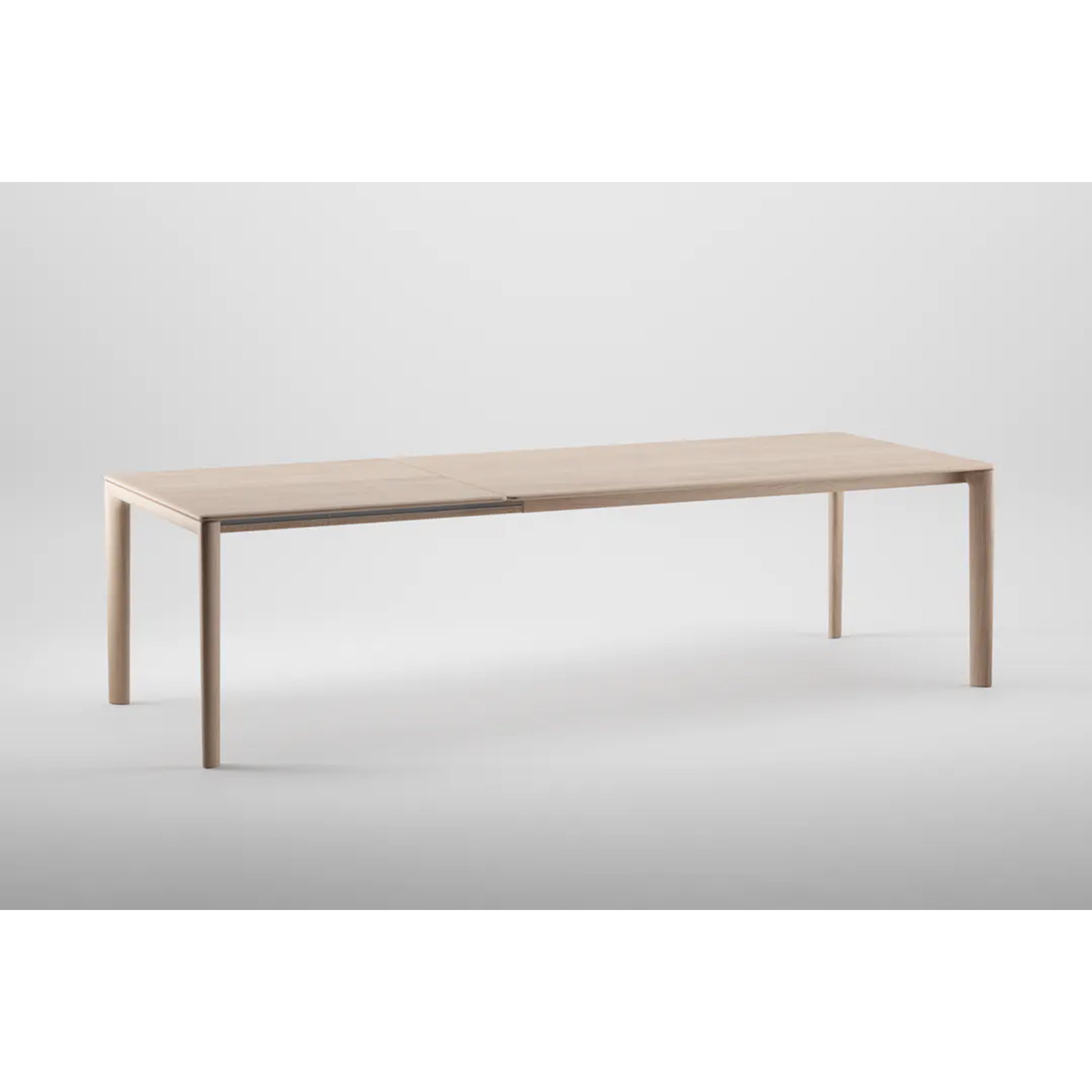 The NEVA Table Extendable by Artisan, made from natural wood, showcases a minimalist design with clean lines and slender legs against a plain gray background.