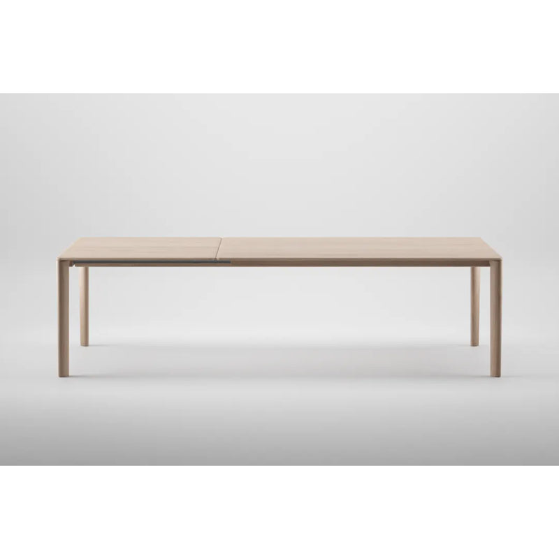 Meet the NEVA Table Extendable by Artisan: a minimalist design crafted from natural wood, featuring a light finish and sleek, straight legs, set against a plain white background.