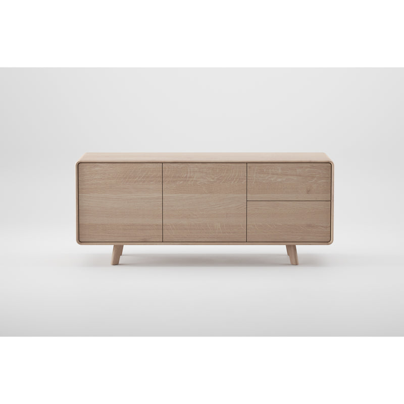The NEVA Sideboard by Artisan is a handcrafted masterpiece with a minimalist design, featuring a natural light oak facade with three doors on short, angled legs against a white background.