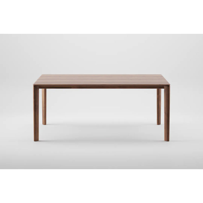The NEVA Table by Artisan is a wooden piece with straight legs and a rectangular top that highlights artisanal craftsmanship. Set on a plain white background, it exudes timeless elegance.