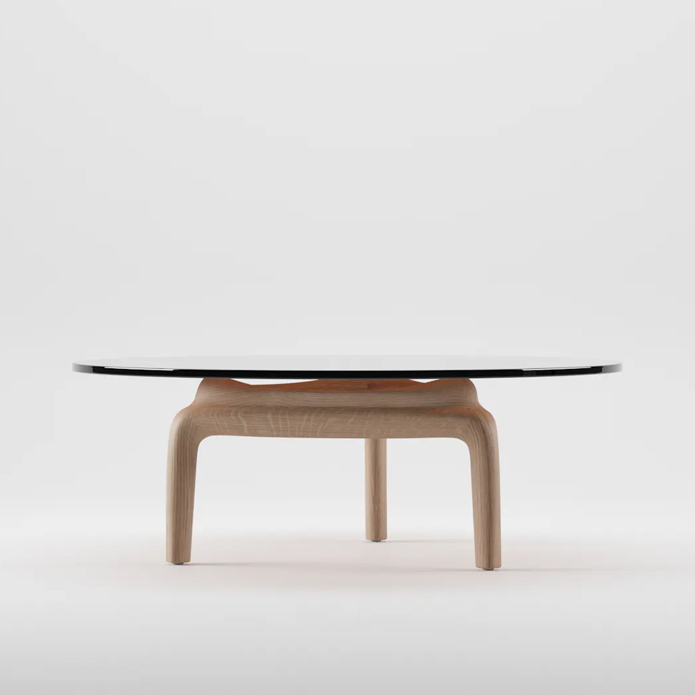 The PASCAL Coffee Table by Artisan features a contemporary design with a black glass top and solid light wooden legs, set against a plain white background.