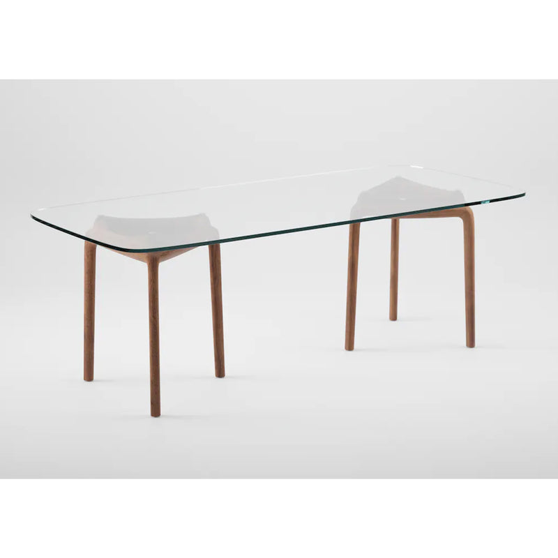 The PASCAL Rectangular Table by Artisan features a clear glass top with solid wood curved legs, set against a plain white background.