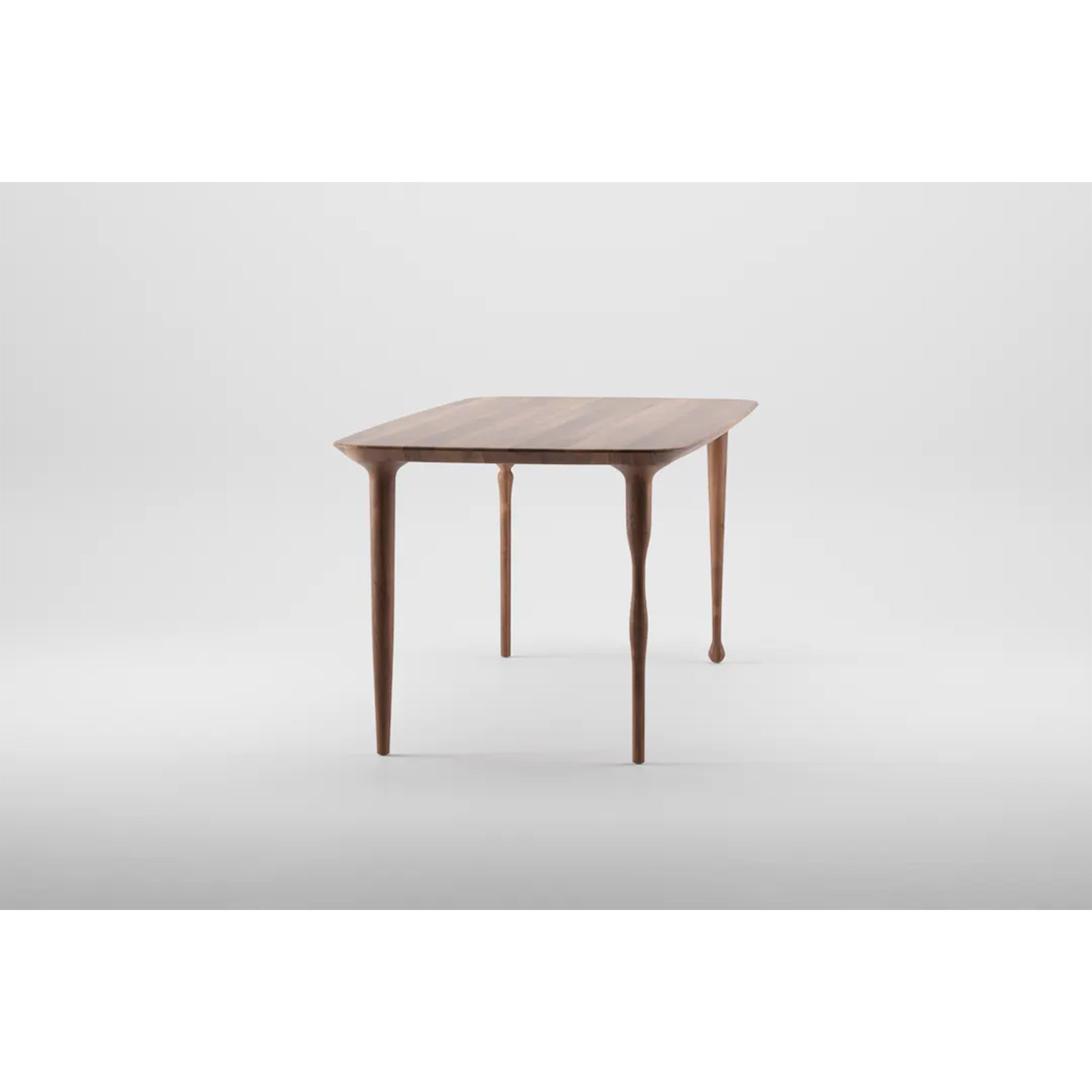 The PASHA Table by Artisan is a modern masterpiece with a rectangular top and elegantly tapered legs. Displayed against a plain white background, it features minimalist design with smooth, rounded edges.