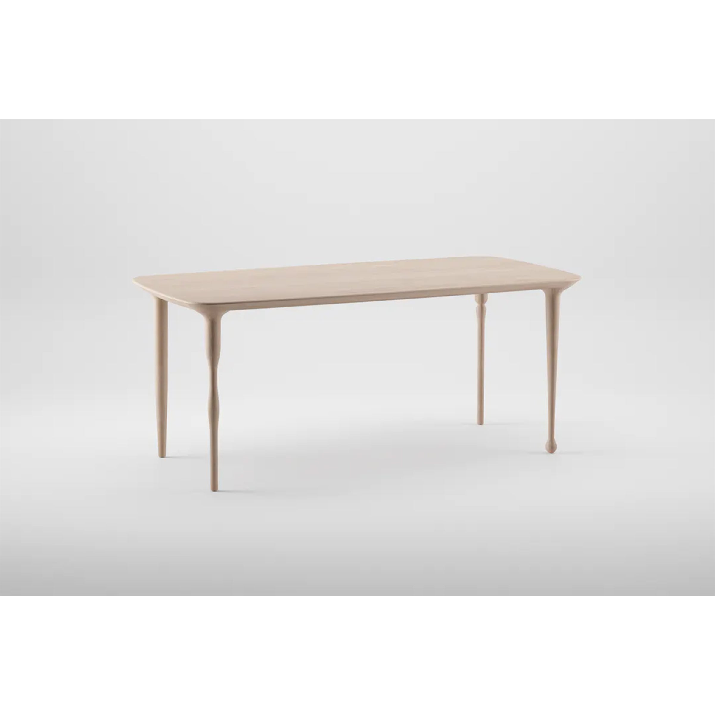 The PASHA Table by Artisan is a minimalist wooden design featuring a light finish. It stands on four elegantly tapered legs against a plain white background, embodying simplicity and elegance.