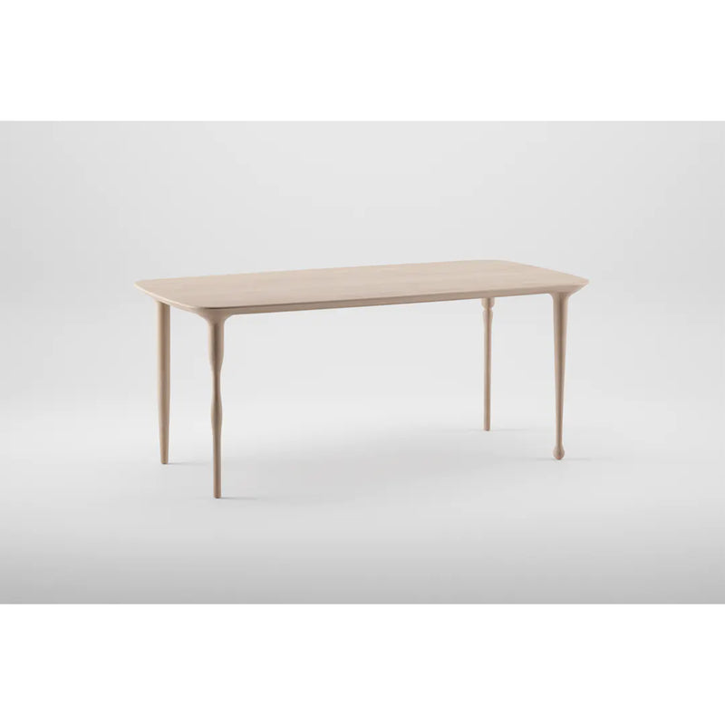 The PASHA Table by Artisan is a minimalist wooden design featuring a light finish. It stands on four elegantly tapered legs against a plain white background, embodying simplicity and elegance.