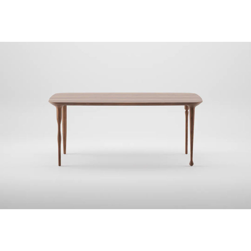 The PASHA Table by Artisan features a smooth rectangular wooden top and four slender, elegantly tapered legs, set against a plain white background.