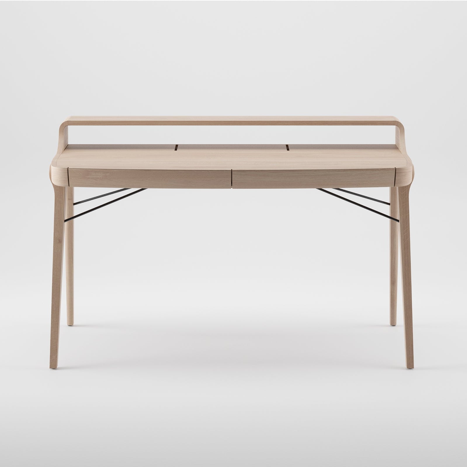 The Artisan PICARD Desk is a minimalist piece crafted from solid wood. It features four sleek legs, a raised back edge, subtle storage compartments, and black metal supports for added stability. Its plain light backdrop enhances its elegance and allows for customization.