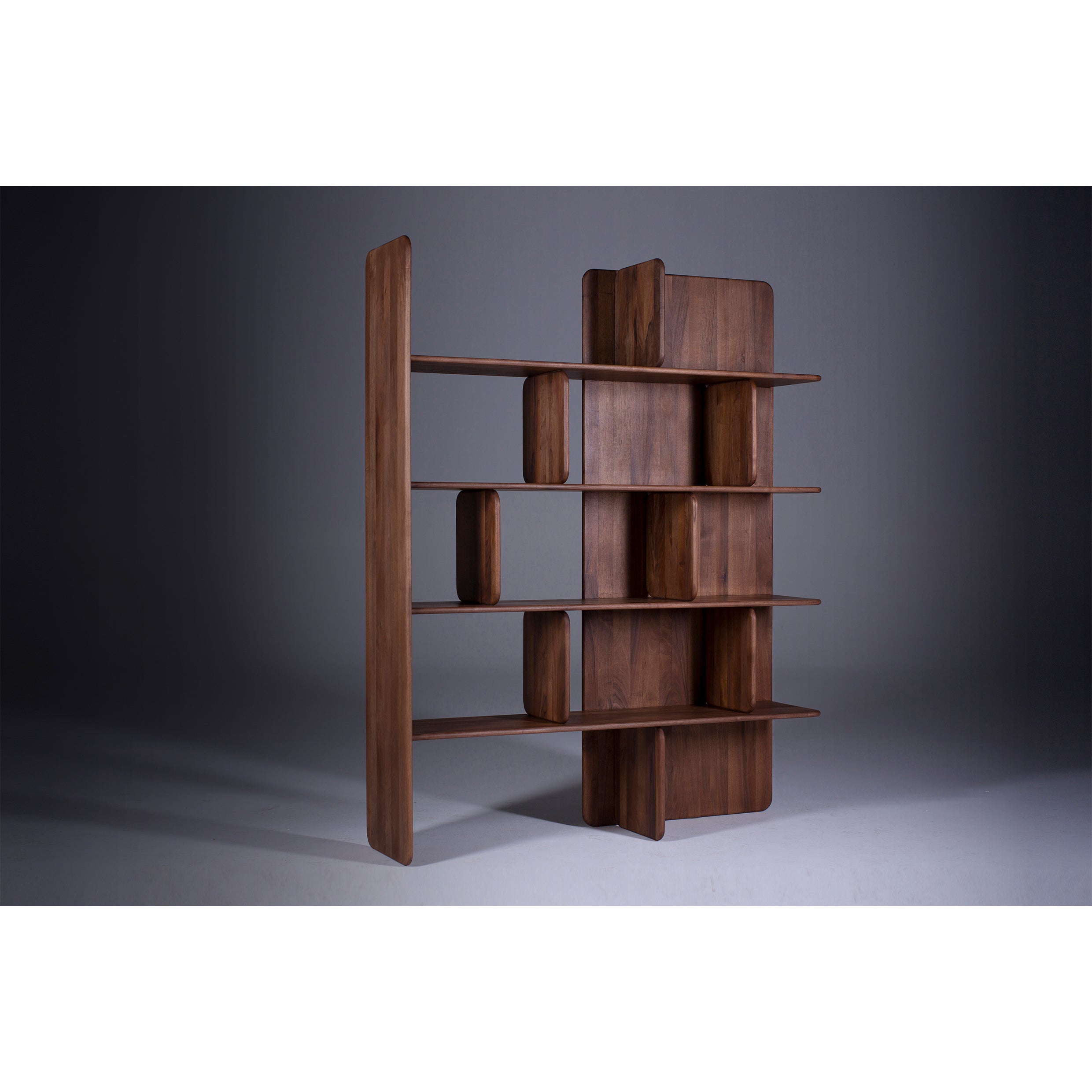 The Artisan SOFT Shelf - IVENTORY is a modern, freestanding unit crafted from solid wood featuring irregularly shaped shelves and partitions in a dark, natural finish. Its minimalist design gracefully stands on a neutral gray background, emphasizing its eco-friendly appeal.