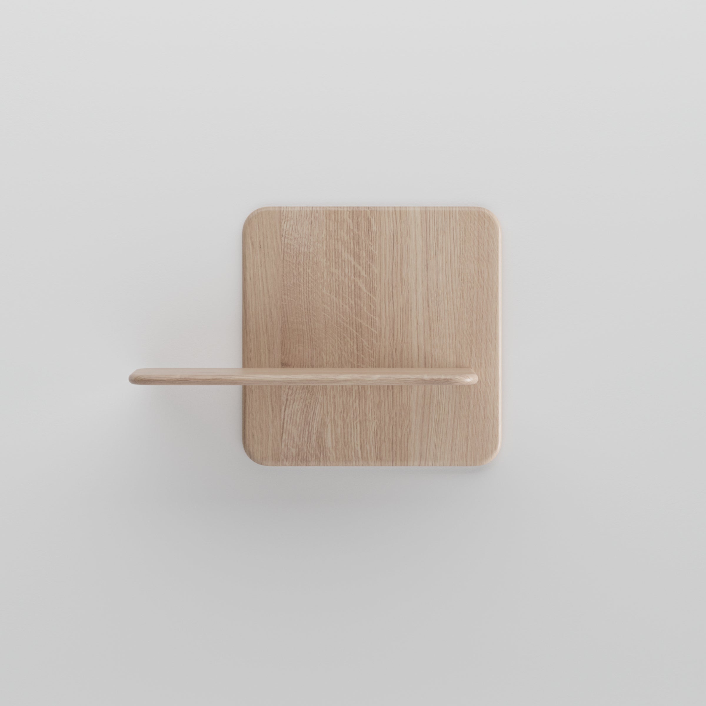 The Soft Wall Modules by Artisan showcase a minimalist wooden shelf with a rectangular base and horizontal ledge, perfect for mounting on a white wall. Crafted from organic materials, it has a light natural finish, highlighting the woods elegance in its simplest form.