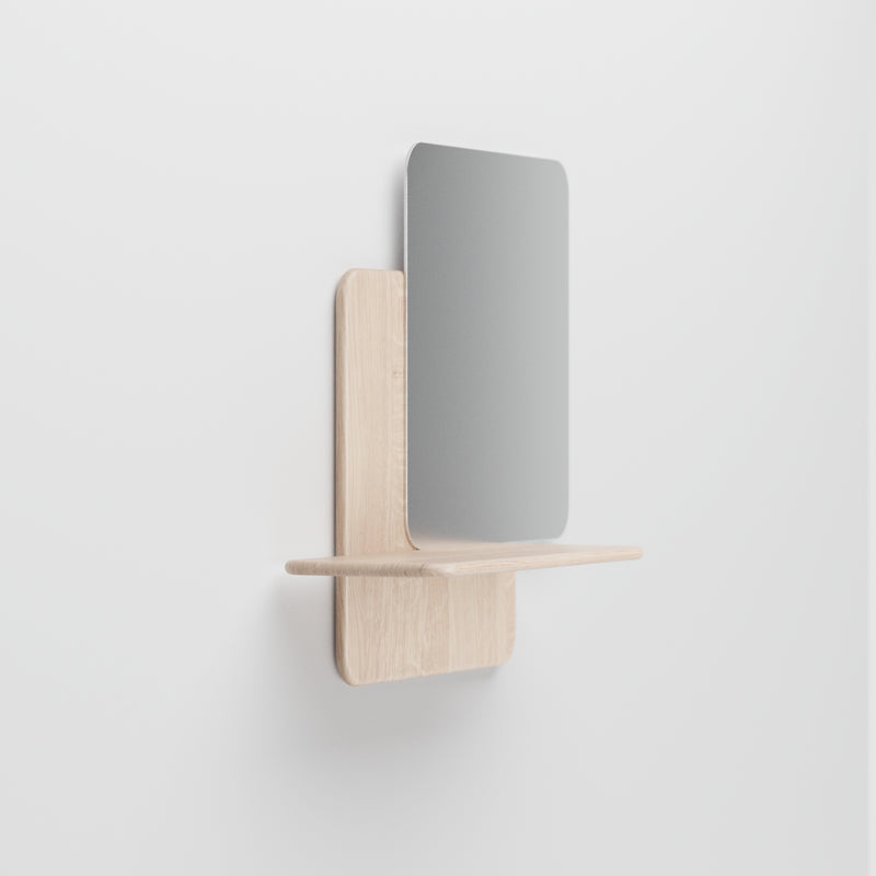 The Soft Wall Modules by Artisan feature a minimalist wall-mounted shelf with a small rectangular mirror, crafted from organic materials. This elegant piece showcases a clean, modern design against a plain white background.