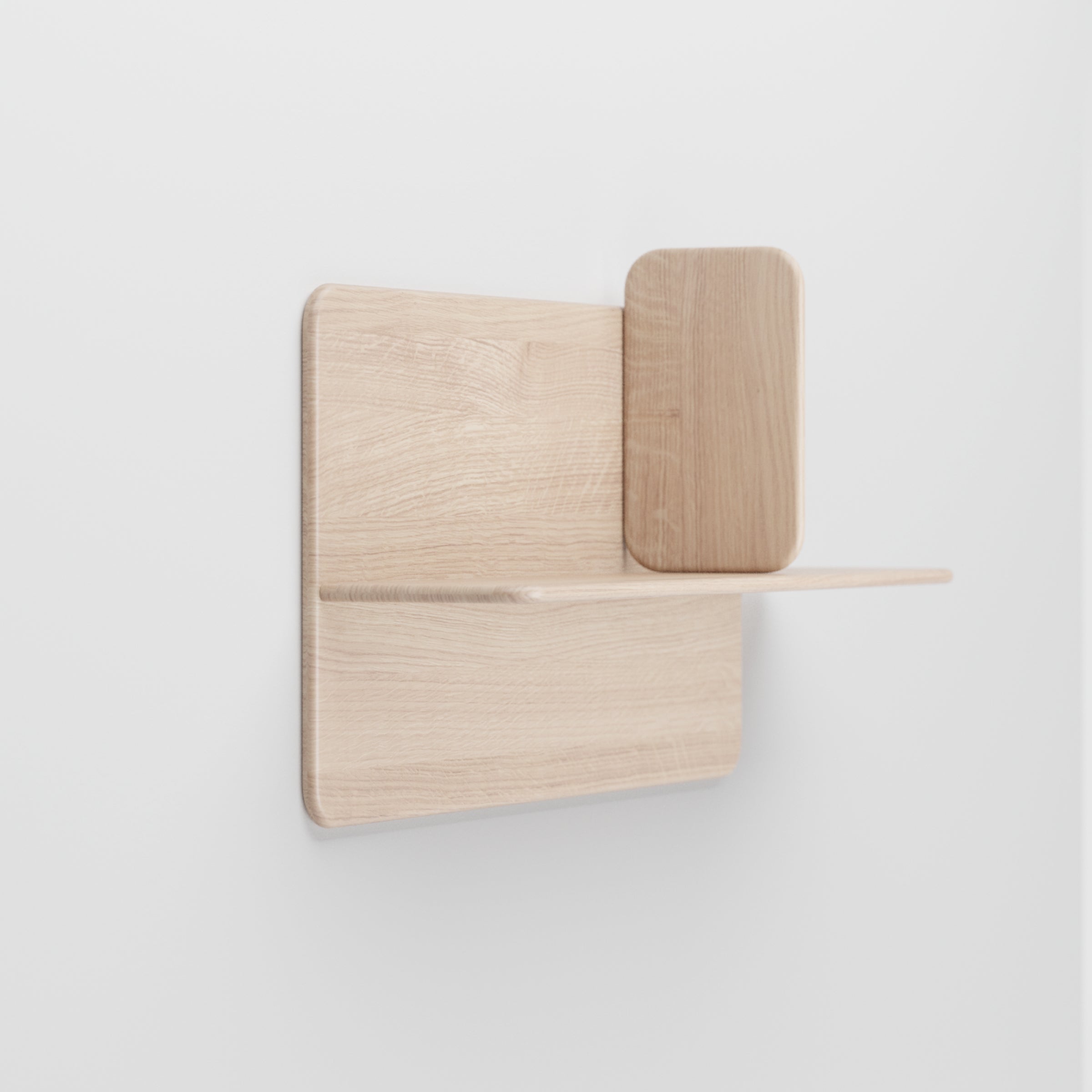 Part of Artisans Soft Wall Modules, this minimalist wall shelf is crafted from organic wood with a light natural finish. Its modern design features two levels: a flat base and an elevated back panel with rounded edges, ideal for a plain white wall.