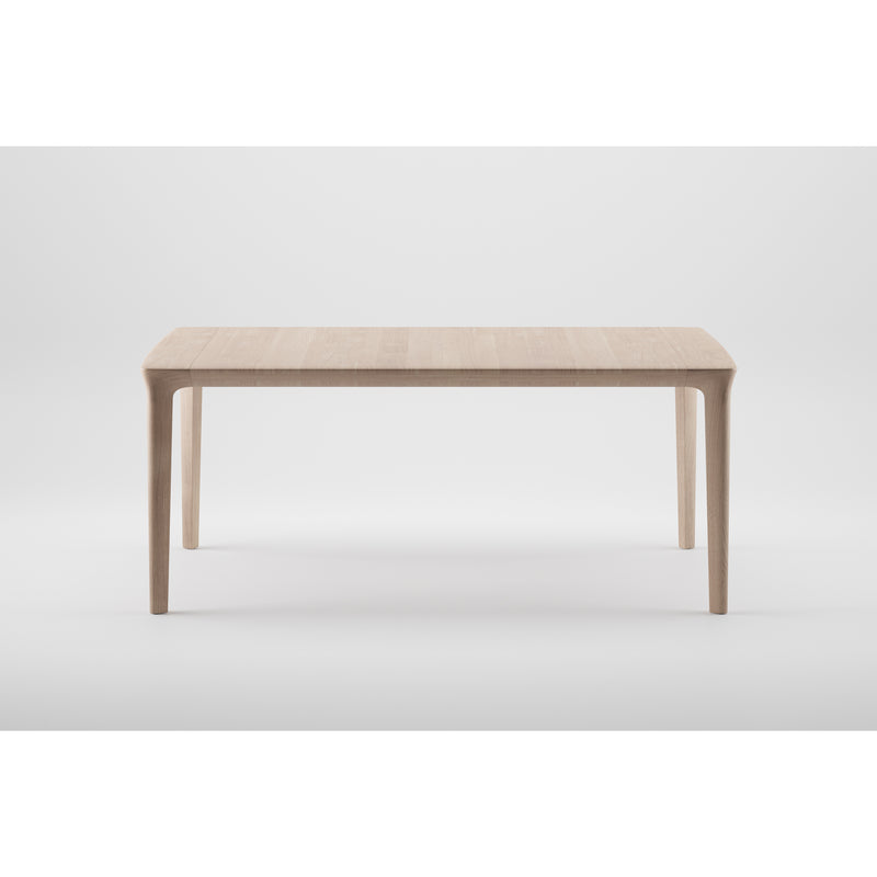 The TARA Table by Artisan is a minimalist solid wood piece with a rectangular top and four tapered legs. Set against a white background, it highlights its simple, elegant design and the organic beauty of eco-friendly materials.