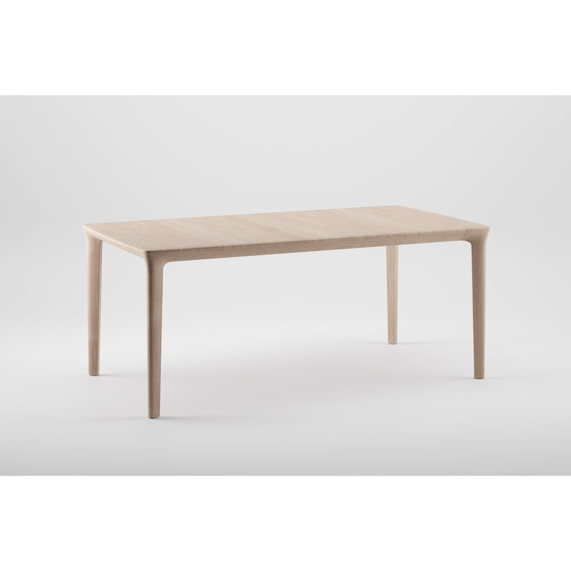 The Artisan TARA Extendable Table showcases organic beauty with its rectangular surface and slender legs, crafted from solid wood, set against a plain white background.