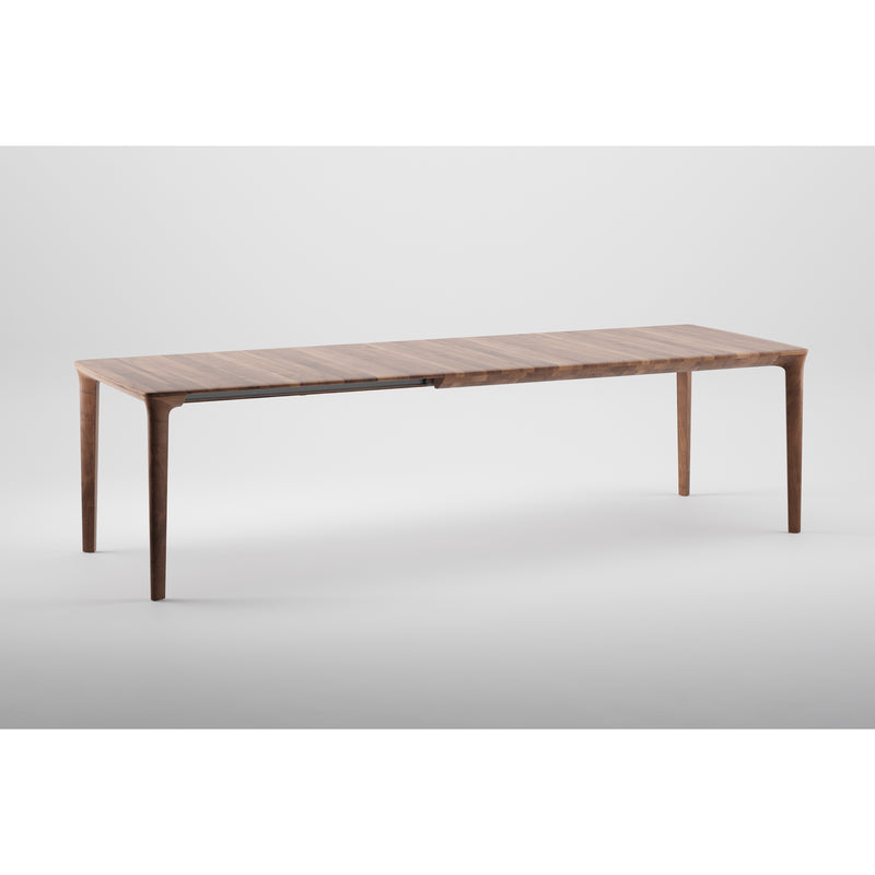 The TARA Extendable Table by Artisan features a long, rectangular design crafted from solid wood with a smooth surface and tapered legs, highlighting its natural beauty against a plain white background.