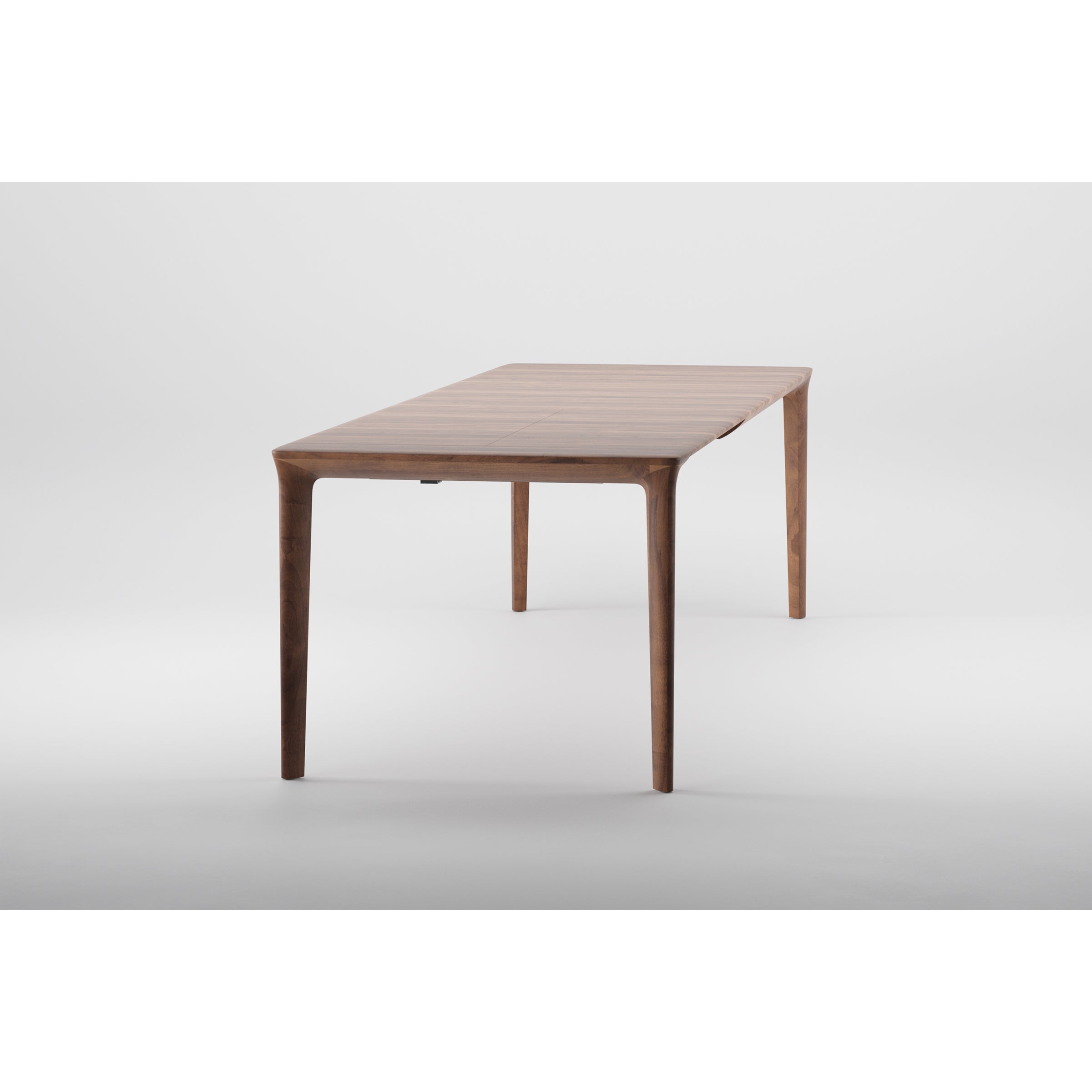 The TARA Extendable Table by Artisan is a sleek, modern wooden piece with a rectangular top and four slim legs. Its natural wood finish highlights minimalist design and eco-friendly choice, set against a plain white background.