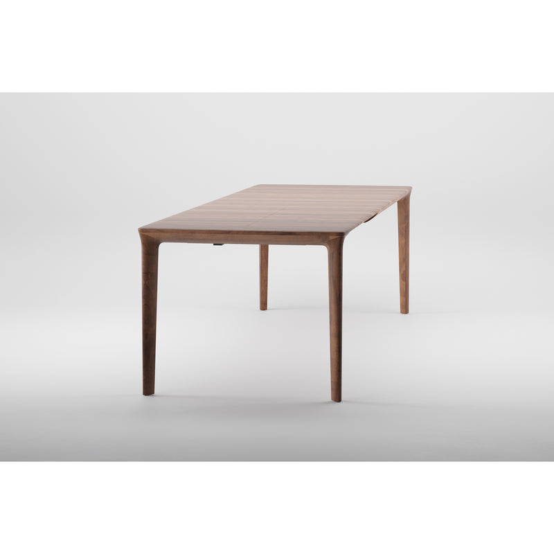 The TARA Extendable Table by Artisan is a sleek, modern wooden piece with a rectangular top and four slim legs. Its natural wood finish highlights minimalist design and eco-friendly choice, set against a plain white background.