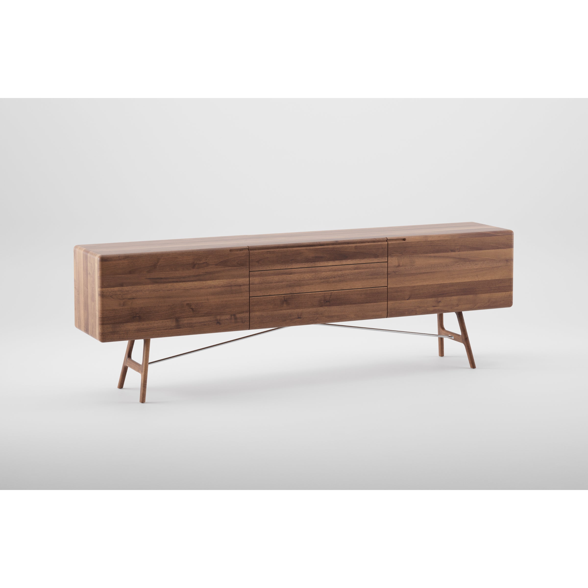 The TESA Sideboard by Artisan is a sleek, environmentally-friendly piece crafted from solid dark wood and treated with natural oils for a rich finish. It features three drawers and stands on four angled legs, adding elegance against a neutral gray background.