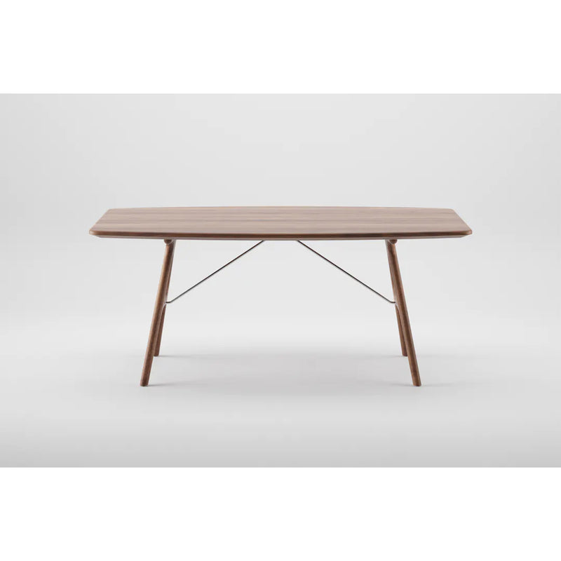 The Artisan TESA Table features a minimalist rectangular solid wood top with angled legs, enhanced by natural oils. Supported by metal crossbars beneath, its elegant design stands out against a plain white background.