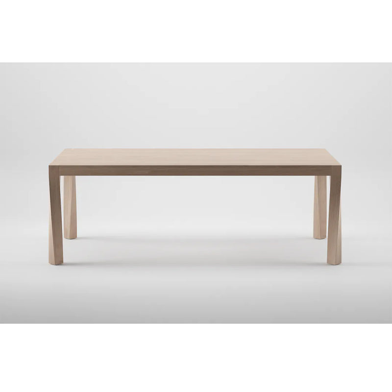 The Artisan TOR Table is a minimalist wooden piece, crafted from solid wood with a light natural finish. With its rectangular top and four straight legs, it accentuates an organic beauty and simple modern design against a plain white background.