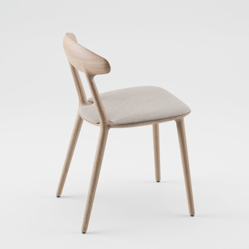 The WU Chair Upholstered by Artisan features a minimalist design crafted from solid wood with a light finish. It includes a soft white seat cushion and a gently curved backrest, supported by four slender legs, combining elegance with eco-friendliness against a plain white backdrop.