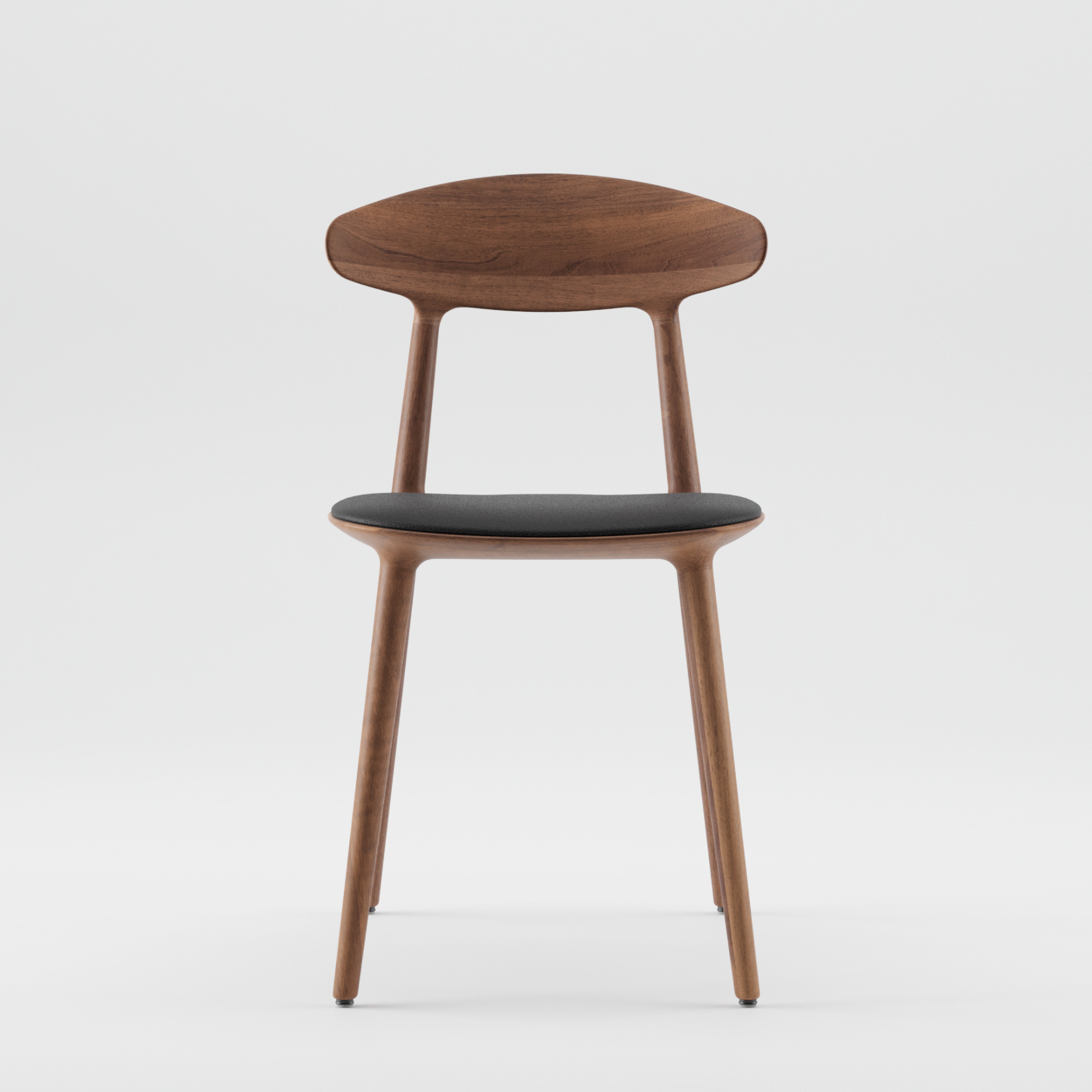 The WU Chair by Artisan is a modern wooden chair made from solid wood and natural oils. It features a curved backrest, black cushioned seat, and smooth, rounded legs in a sleek, minimalist design against a plain white background.