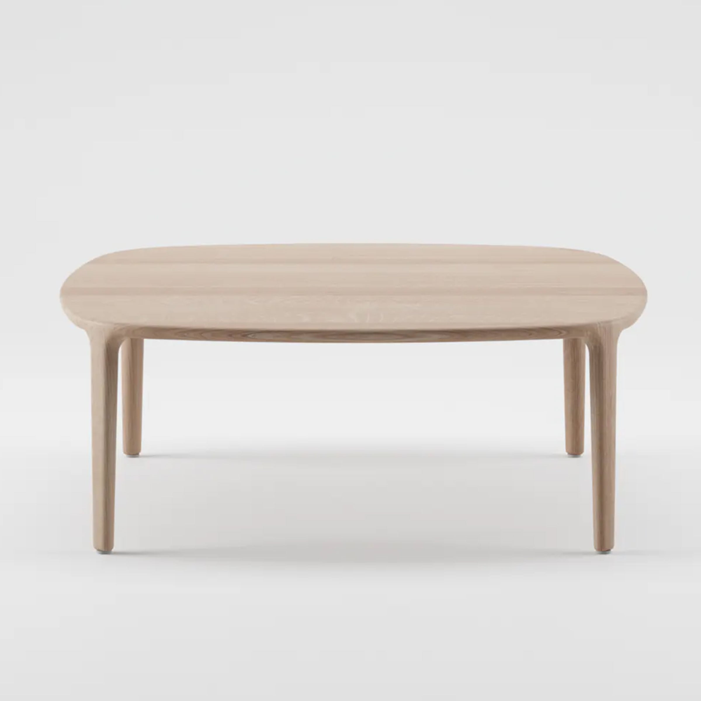 The WU Coffee Table by Artisan is crafted from solid wood with a light, natural finish. It features a smooth, rounded rectangular top on four straight, tapered legs. Made with eco-friendly materials, its elegant and sustainable design stands out against a plain white background.