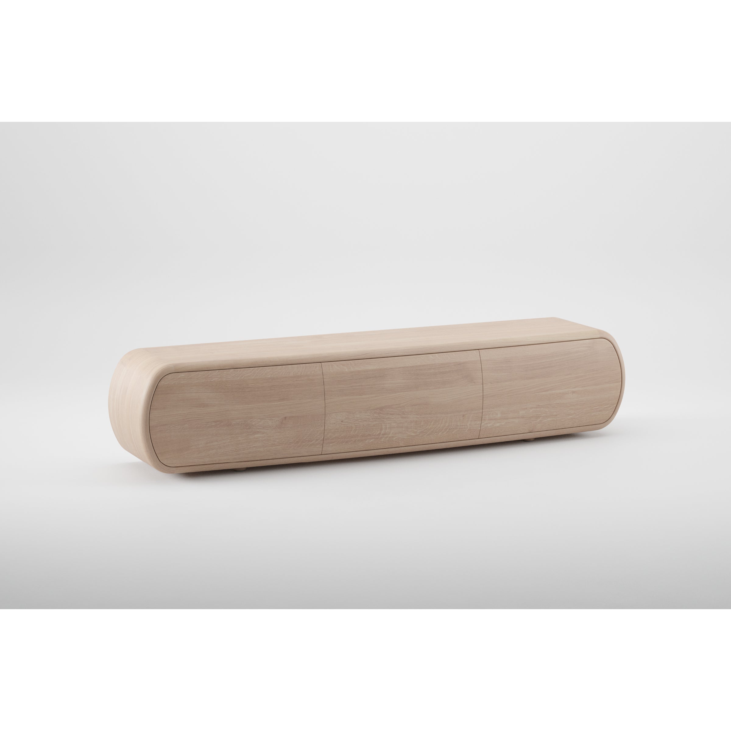 The Artisan WU Sideboard is a minimalist TV stand showcasing the organic beauty of light wood with its rounded edges and sleek, low-profile design. It features three compartments with seamless front panels, crafted from eco-friendly materials against a plain white background.