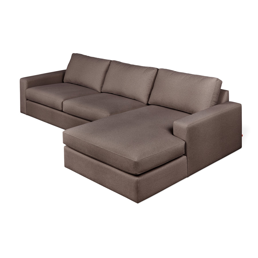 The Gus Modern Ashdale Right-Facing Sectional features a hardwood frame, brown upholstery, wide seat cushions, and three synthetic-down back cushions. The chaise extends left while the armrest is on the right for a sleek, minimalist look.