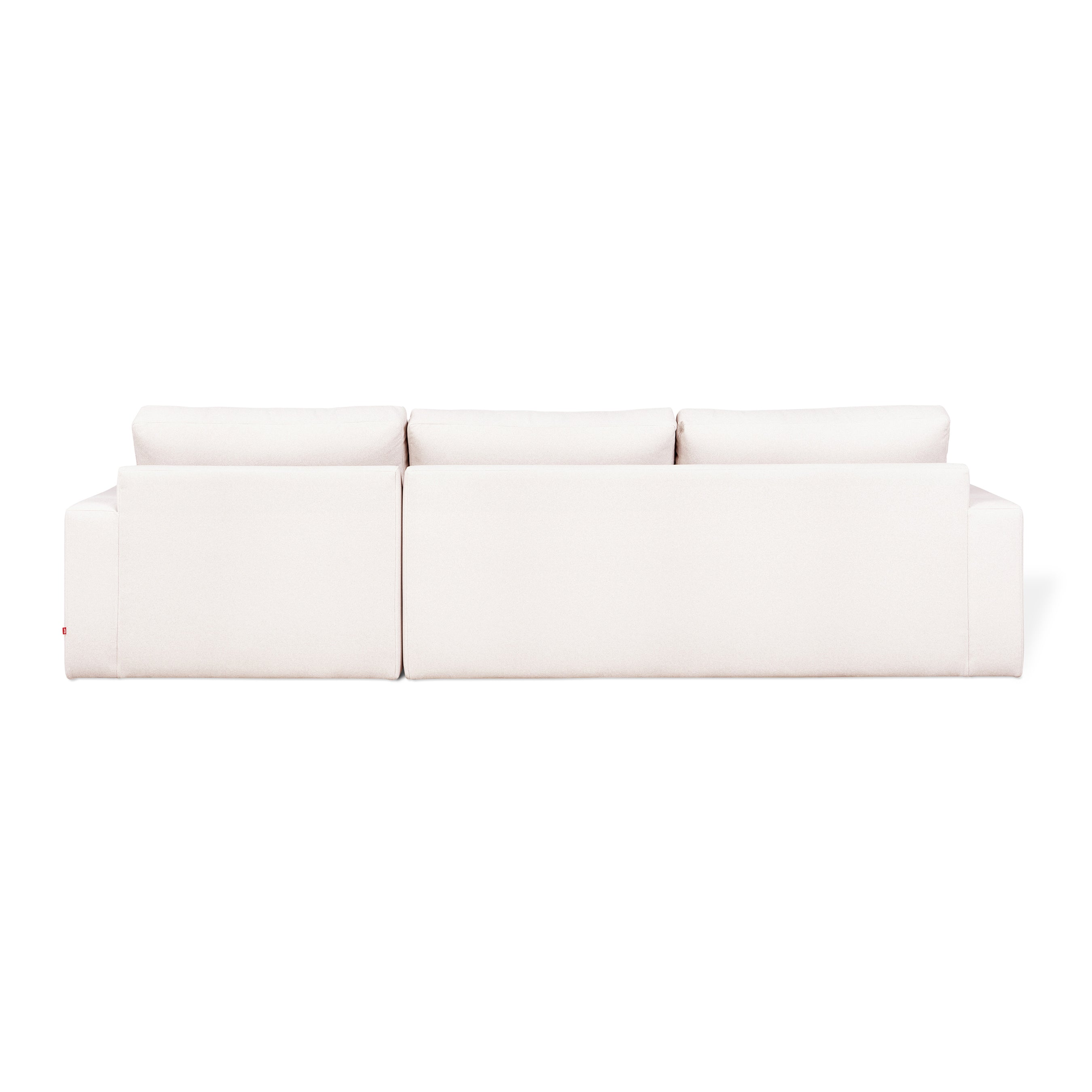 The Gus Modern Ashdale Right-Facing Sectional is a modern white minimalist sofa with clean lines, plush synthetic-down cushions, and a sturdy hardwood frame, shown from the back against a plain white background.