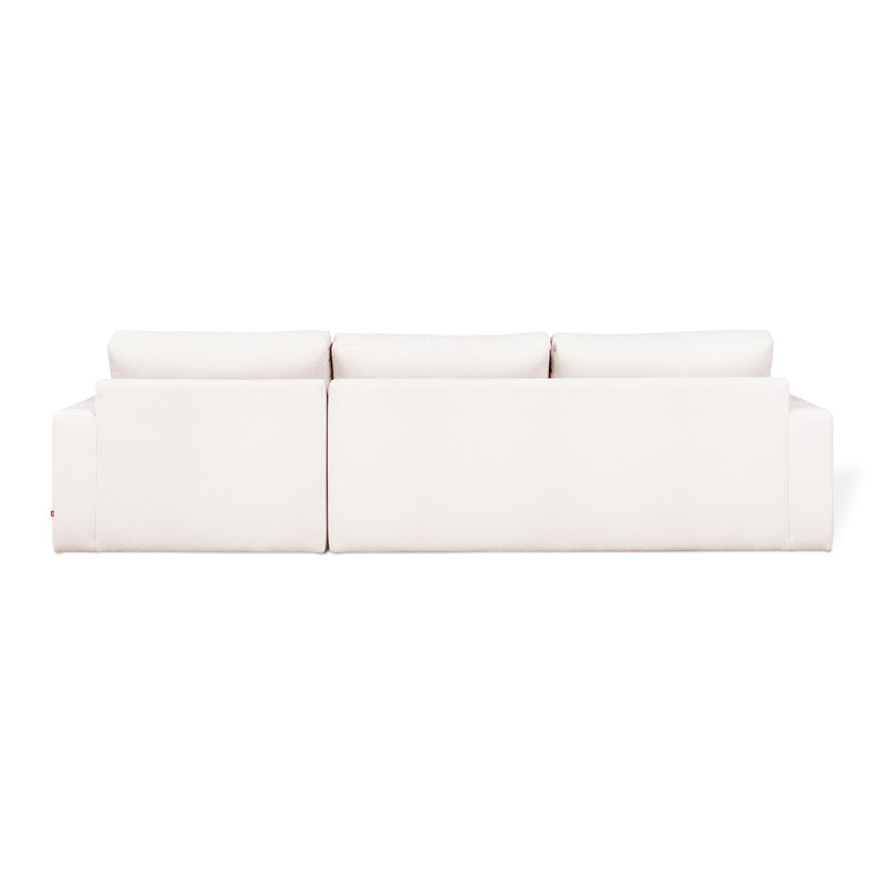 The Gus Modern Ashdale Right-Facing Sectional is a modern white minimalist sofa with clean lines, plush synthetic-down cushions, and a sturdy hardwood frame, shown from the back against a plain white background.