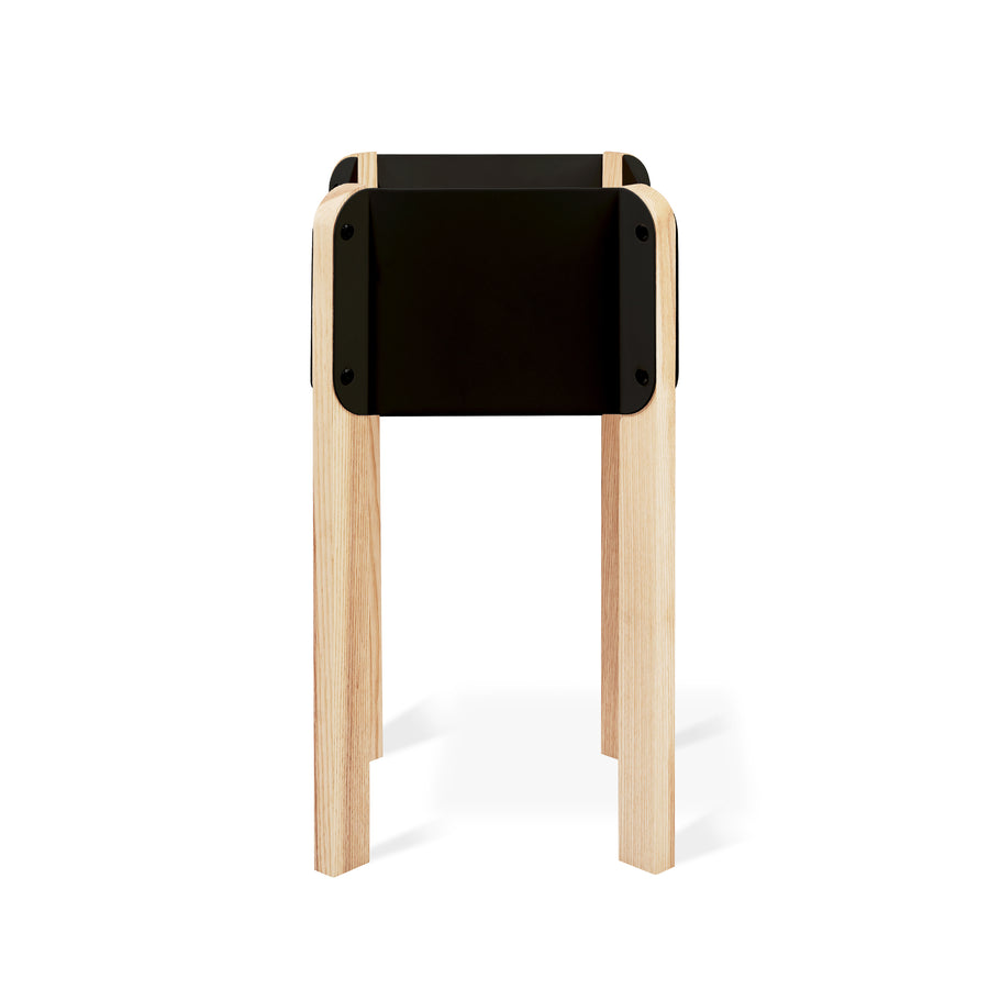 The Atrium Planter Hi by Gus Modern is a minimalist, Bauhaus-inspired black rectangular planter or side table with four light wood legs, shown against a white background.