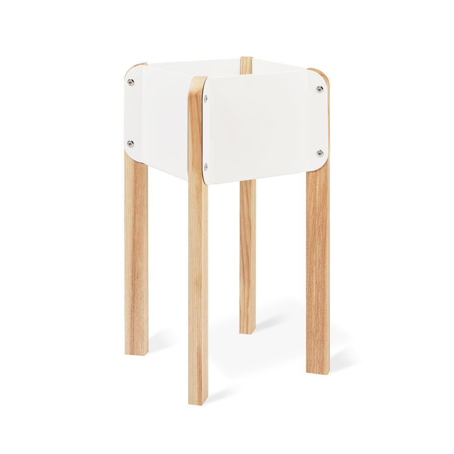 The Atrium Planter Hi by Gus Modern features a modern, minimalist design with four light wood legs and a square white frame inspired by Bauhaus style, shown against a white background.