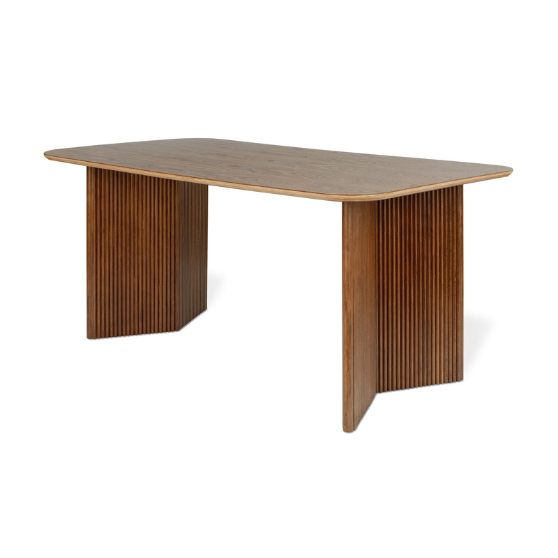 The Atwell Dining Table Rectangle by Gus Modern is a solid wood dining table with a rectangular top, rounded corners, and two wide, vertically-grooved panel legs inspired by Mid-Century Scandinavian design.