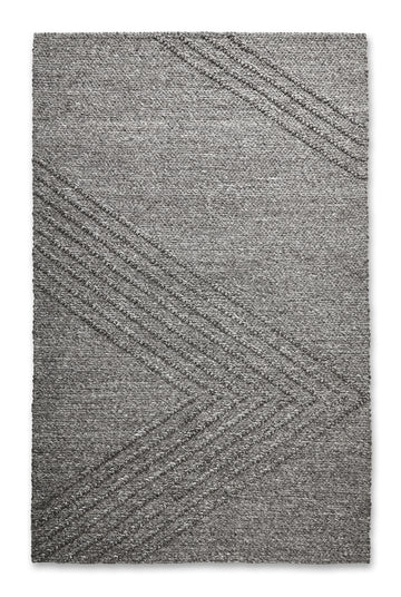 The Avro Rug by Gus Modern is a rectangular gray minimalist rug featuring a subtle chevron pattern with raised diagonal lines, offering a simple, modern look ideal for contemporary spaces.