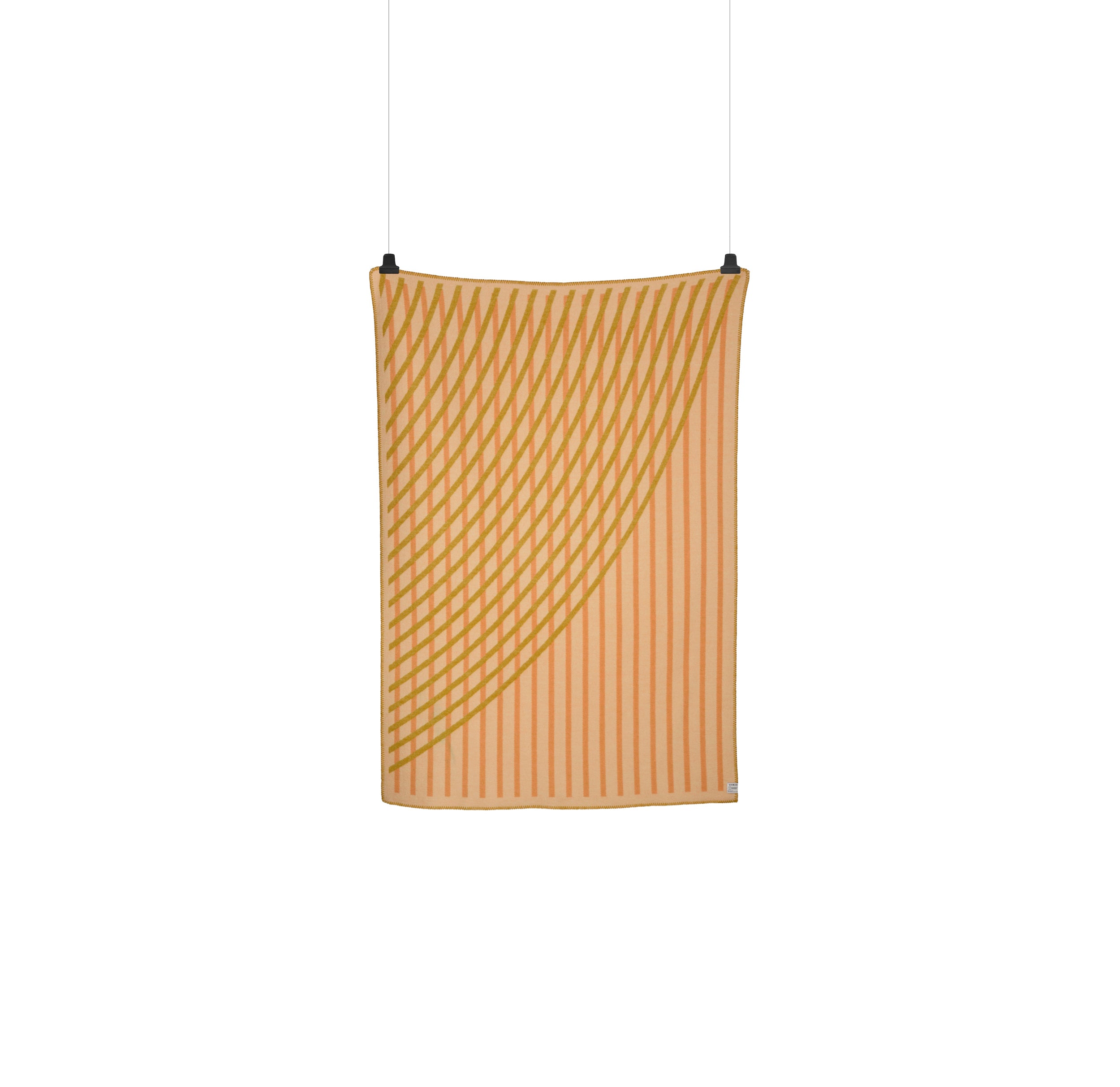 The BISLETT Throw by Roros, featuring a beige and orange geometric pattern reminiscent of the moiré phenomenon, hangs elegantly against a white background, secured by two clips.