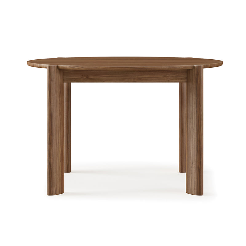 The Bancroft Dining Table Round by Gus Modern is a solid wood dining table with a smooth surface and four thick, cylindrical legs, shown against a plain white background.