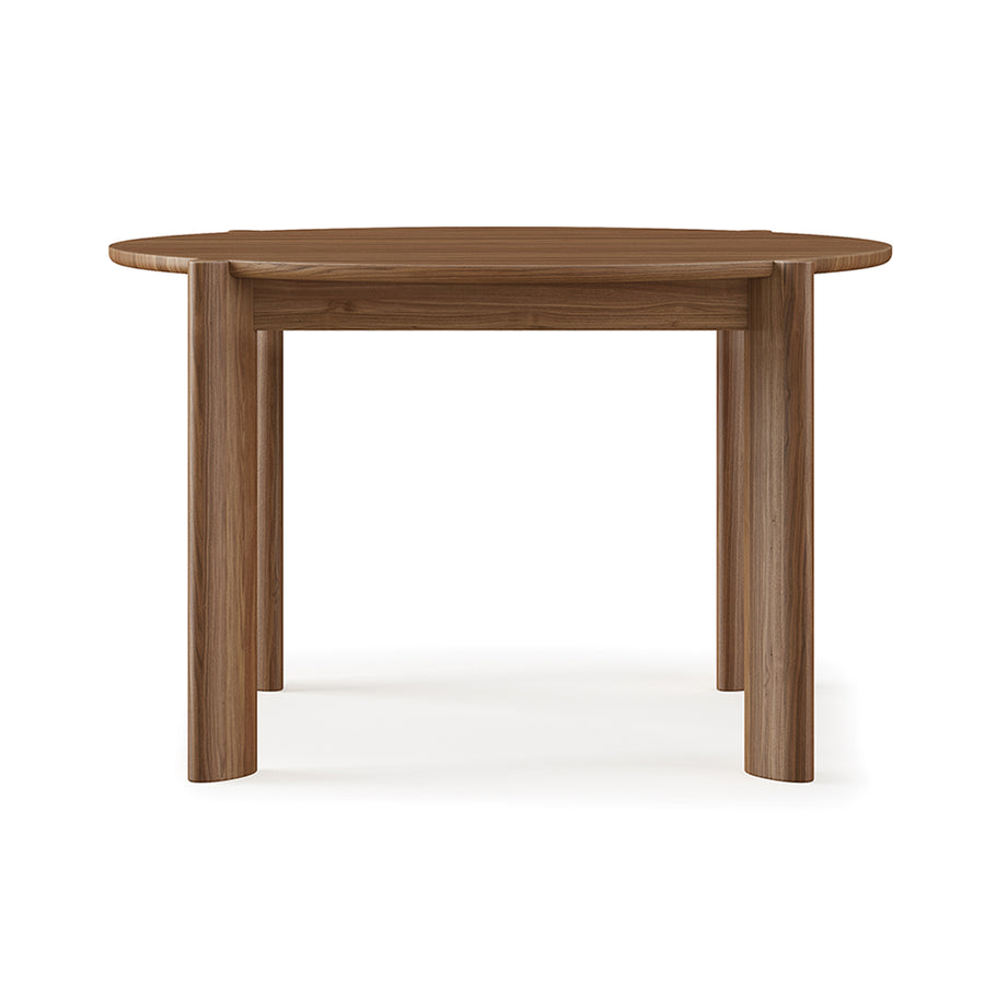 The Bancroft Dining Table Round by Gus Modern is a solid wood dining table with a smooth surface and four thick, cylindrical legs, shown against a plain white background.