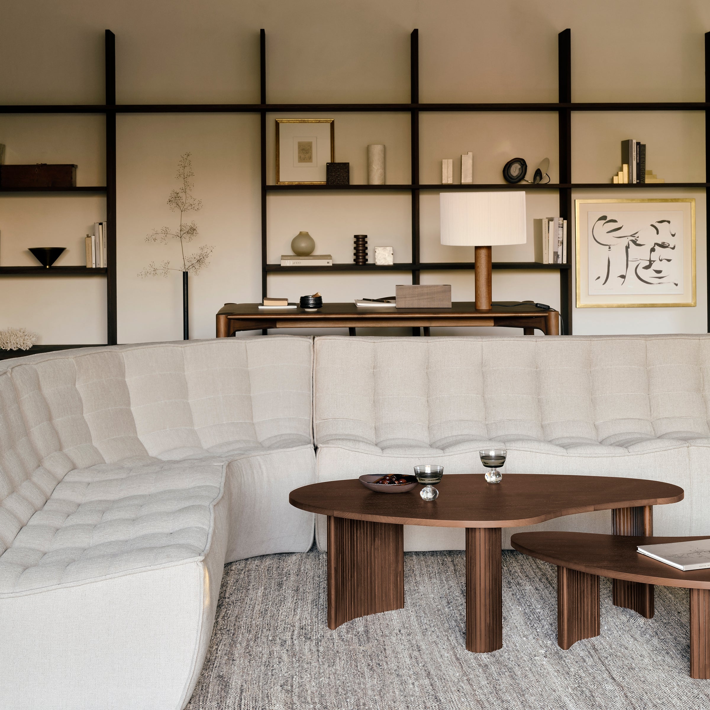 Boomerang Coffee Table in varnished mahogany brown with sleek modern design in a stylish living room setting.