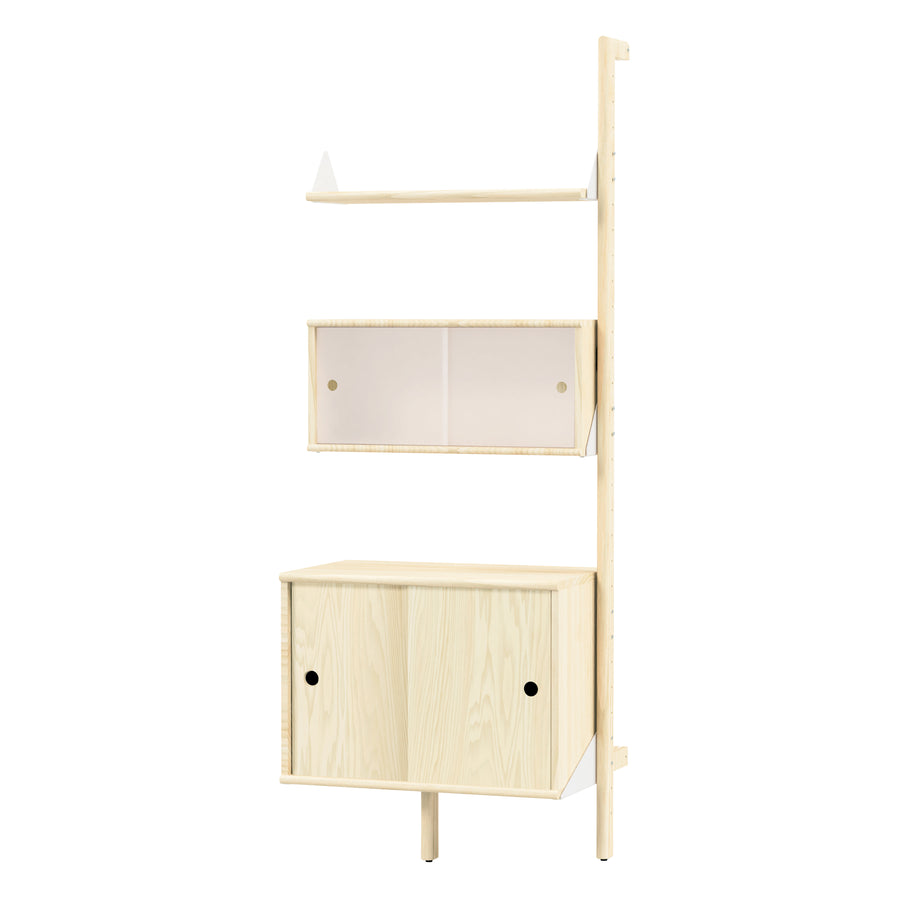 The Gus Modern Branch Multi Storage Unit Add-On is a light wood, wall-mounted, mid-century shelf with three sections: an open top shelf, a middle shelf with two sliding frosted doors, and a bottom cabinet with two wooden sliding doors.