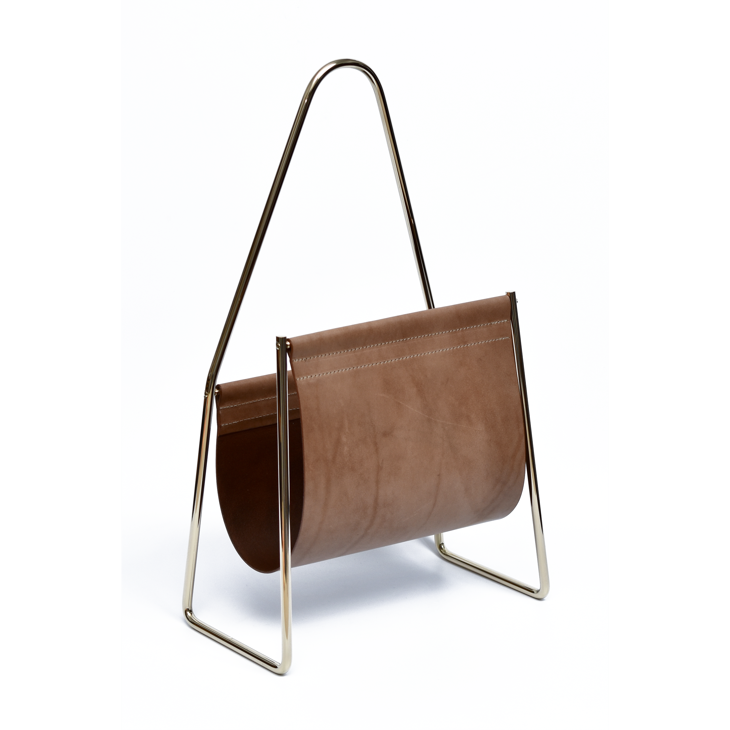 The modern, minimalist Magazine Rack #3808 by Werkstätte Carl Auböck showcases a brass-polished triangular frame and brown leather sling, elegantly holding magazines against a plain white backdrop.