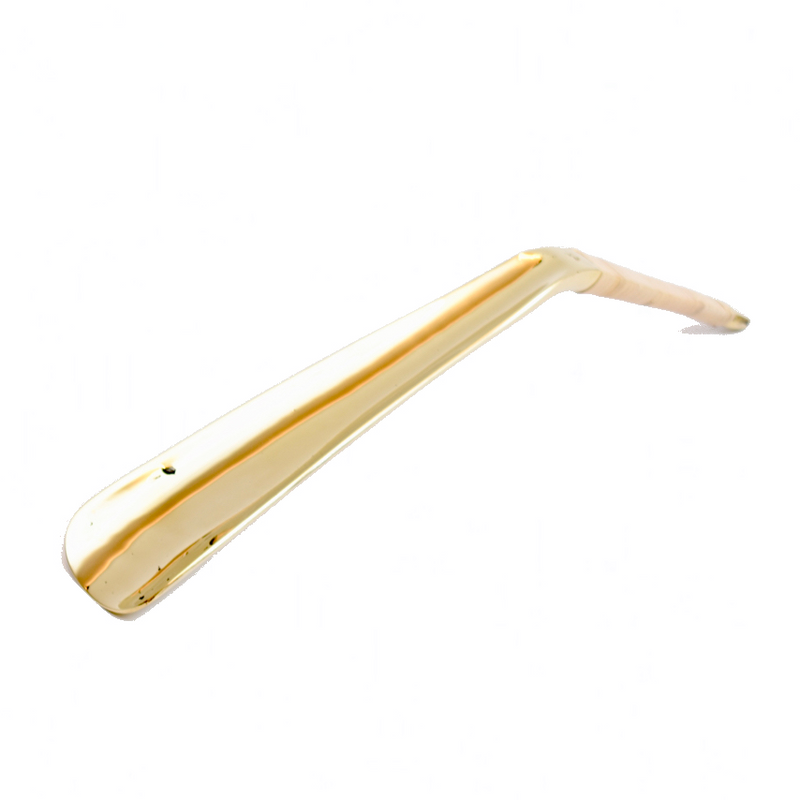 Shoehorn #4225 by Werkstätte Carl Auböck features a sleek, curved design with a shiny gold-toned finish, evoking the brands elegant style. It resembles a modern, minimalist handle or lever against a plain white background.