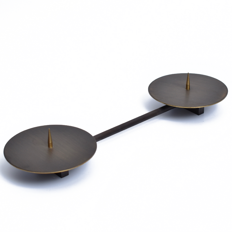 Candle Holder #4800 by Werkstätte Carl Auböck features two brass circular discs connected by a horizontal bar. Each disc, reminiscent of Wiener Bronzen style, has a pointed spike at its center against a plain white background.