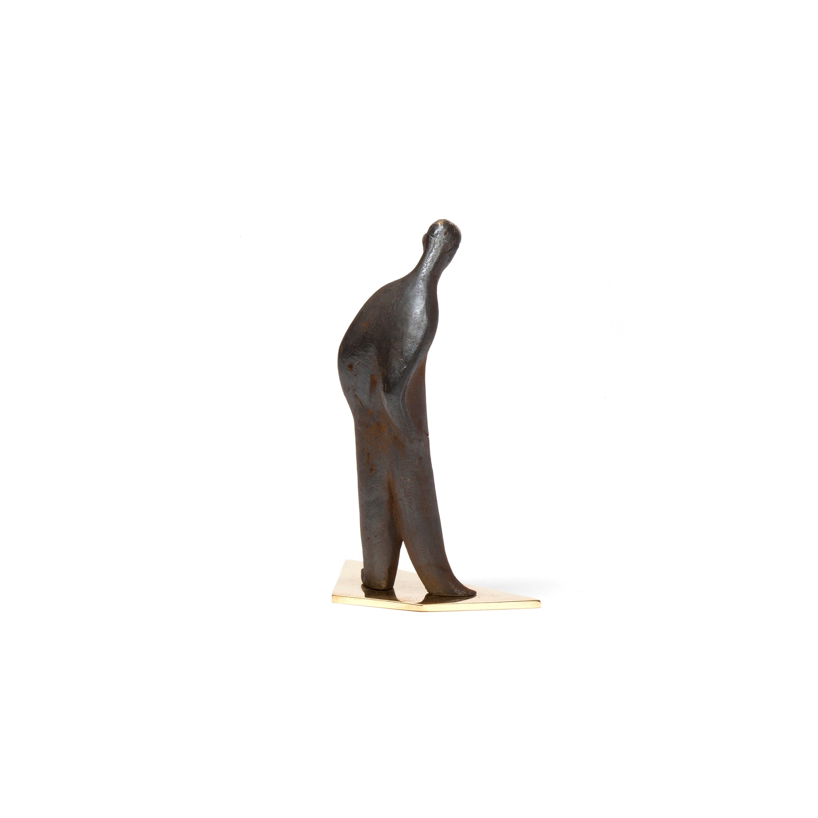 Sculpture #4069 from Werkstätte Carl Auböck is a small, abstract bronze piece with a bent figure on a light triangular base against a white backdrop. Its forward-leaning posture evokes movement and elegance akin to the Triennale di Milano theme.