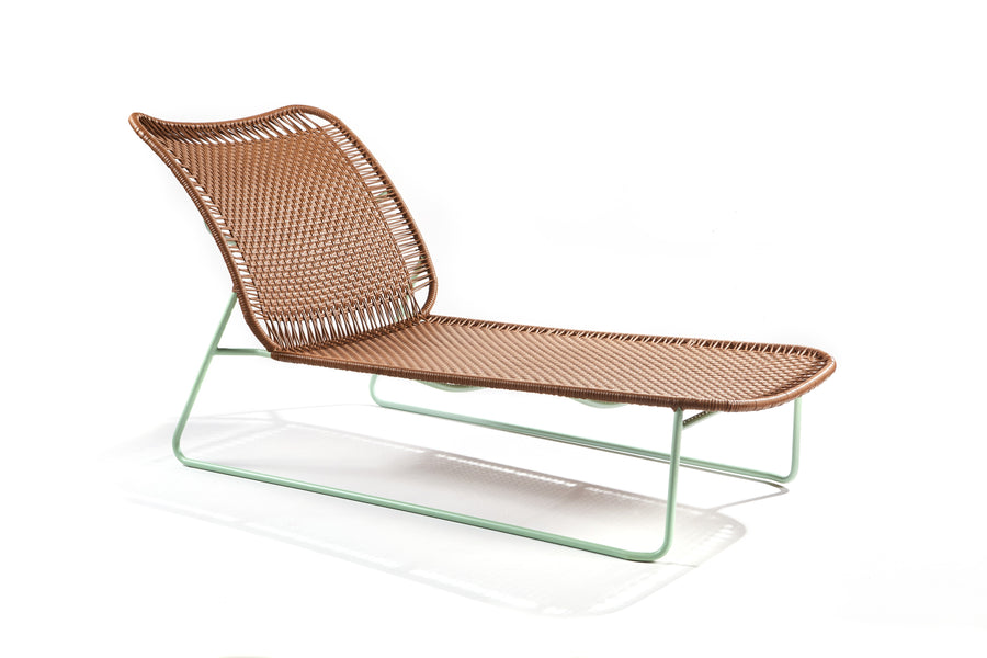 The Ames Cielo Daybed by Ames, designed by Sebastian Herkner, has a woven brown seat and backrest with a minimalist light green metal frame, shown against a plain white background.